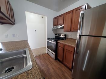 A kitchen with a stainless steel refrigerator, sink, and stove